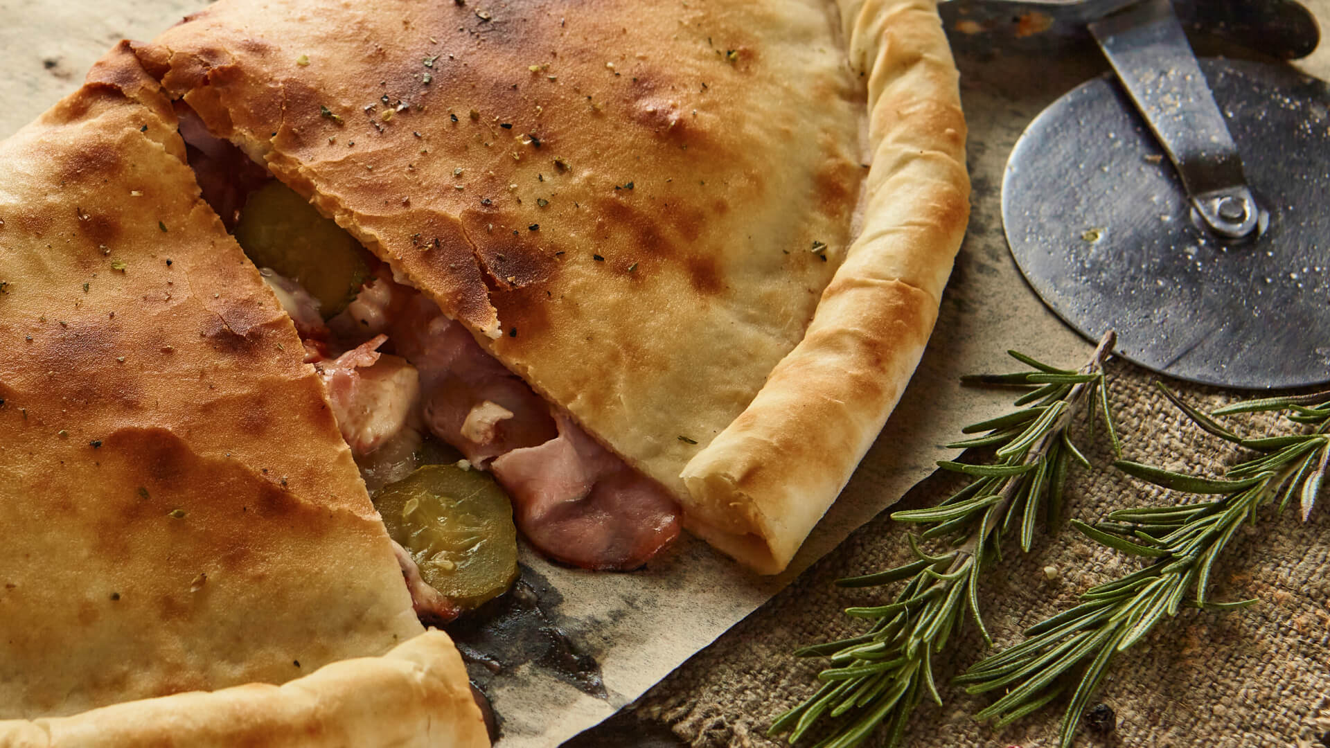 Zdjęcie jedzenia – calzone przekrojone z ziołami