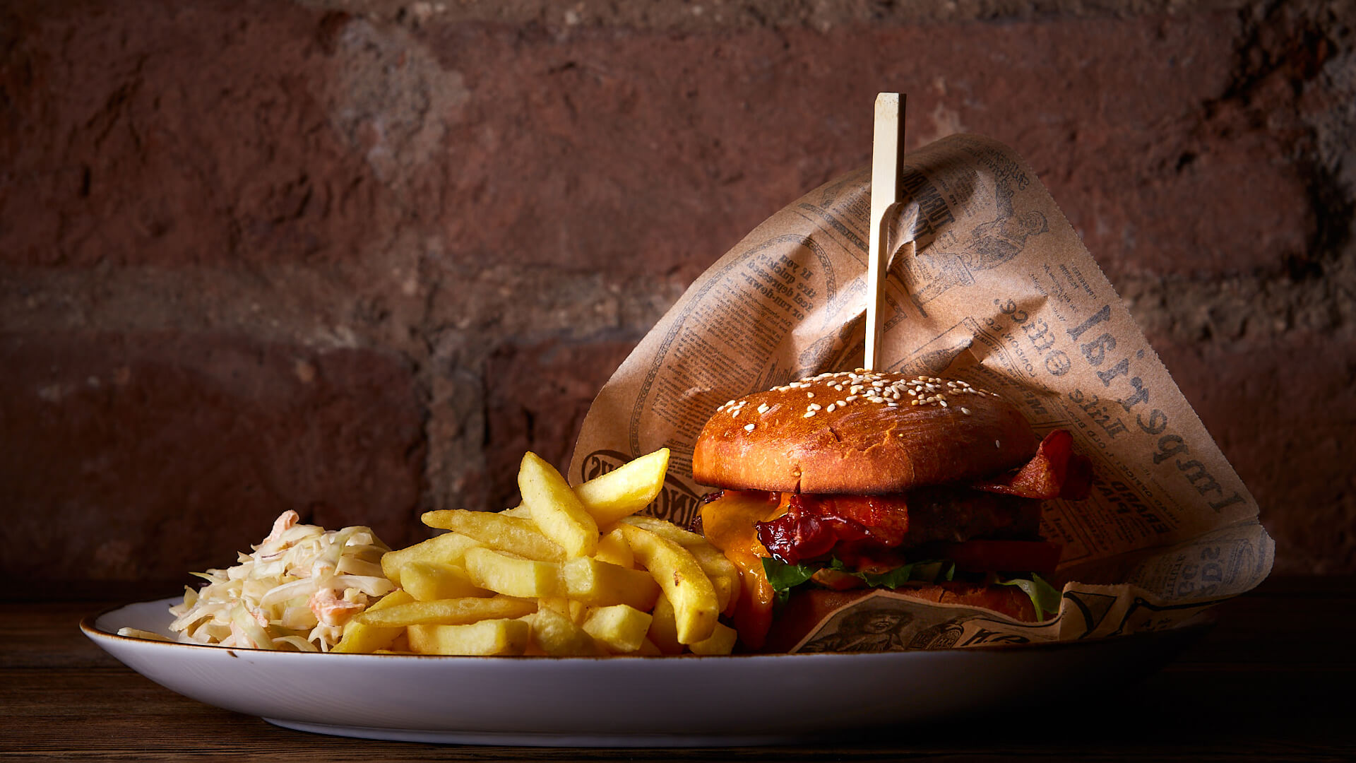 Fotografia jedzenia – burger z frytkami na ciemnym tle