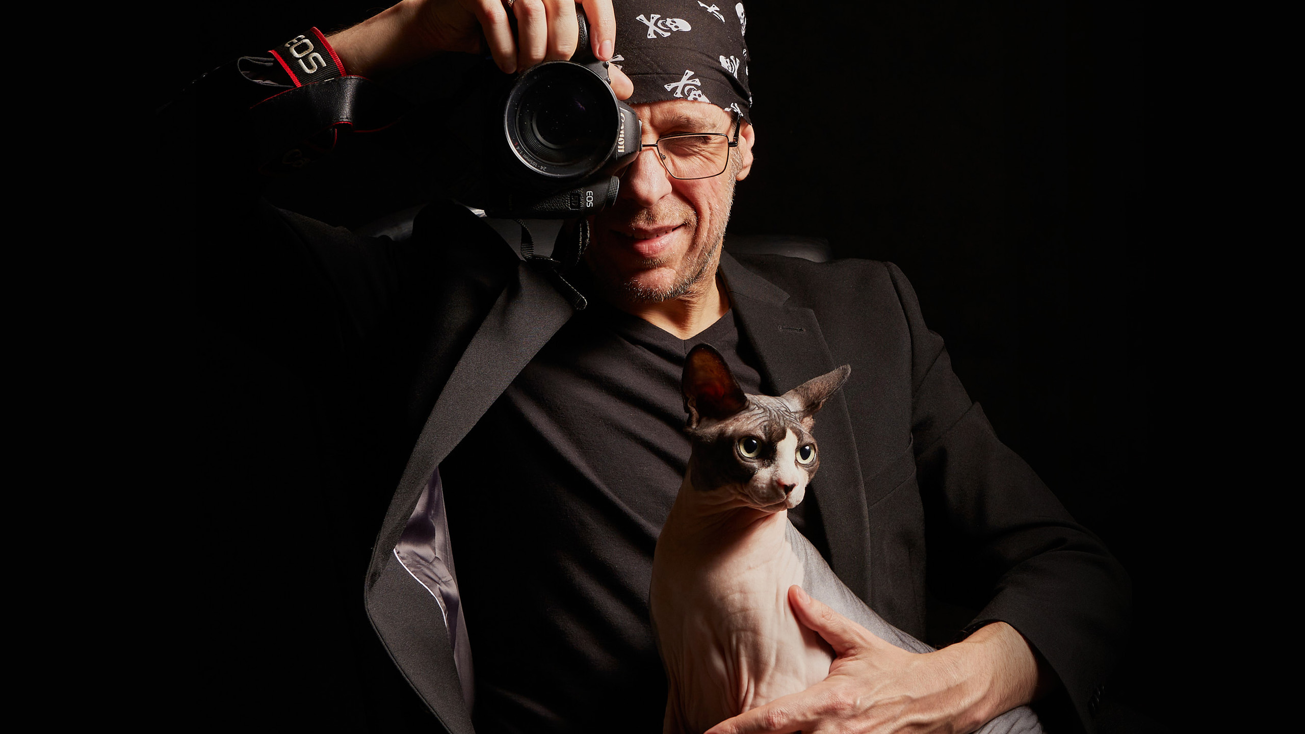 Portret fotografa Sevy Zelikoffa z kotem rasy kanadyjski sfinks