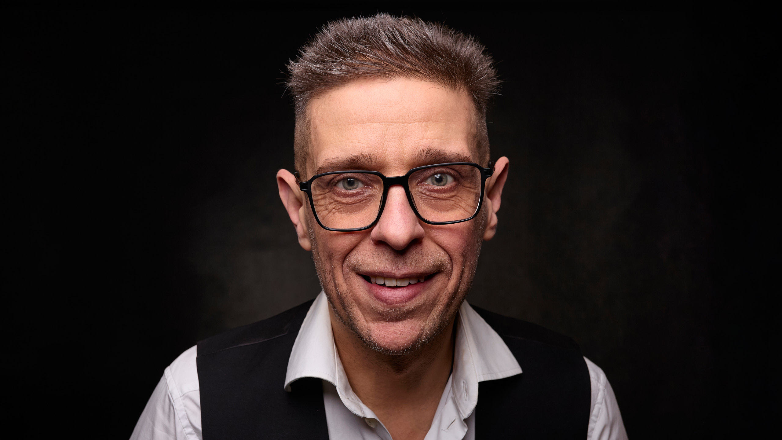 Portrait of photographer Seva Zelikoff on a dark background